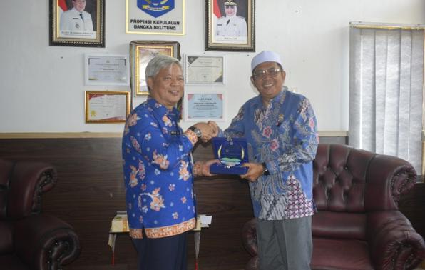 Penyerahan cinderamata dari anggota DPD RI Uzt. H.Zuhri kepada Plt Kepala DINSOSPMD, Tarmin