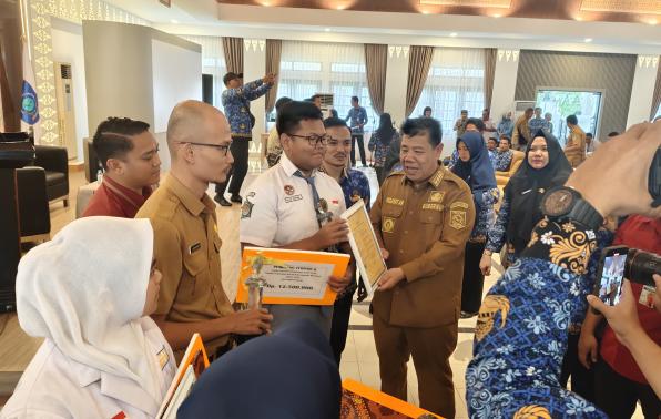 Gubernur Hidayat Arsani didampinngi Plh Kadinsospmd, Tarmin, menyerahkan hadiah dan piagam kepada pemenang lomba TTG dan LOMDESKEL Tingkat Provinsi